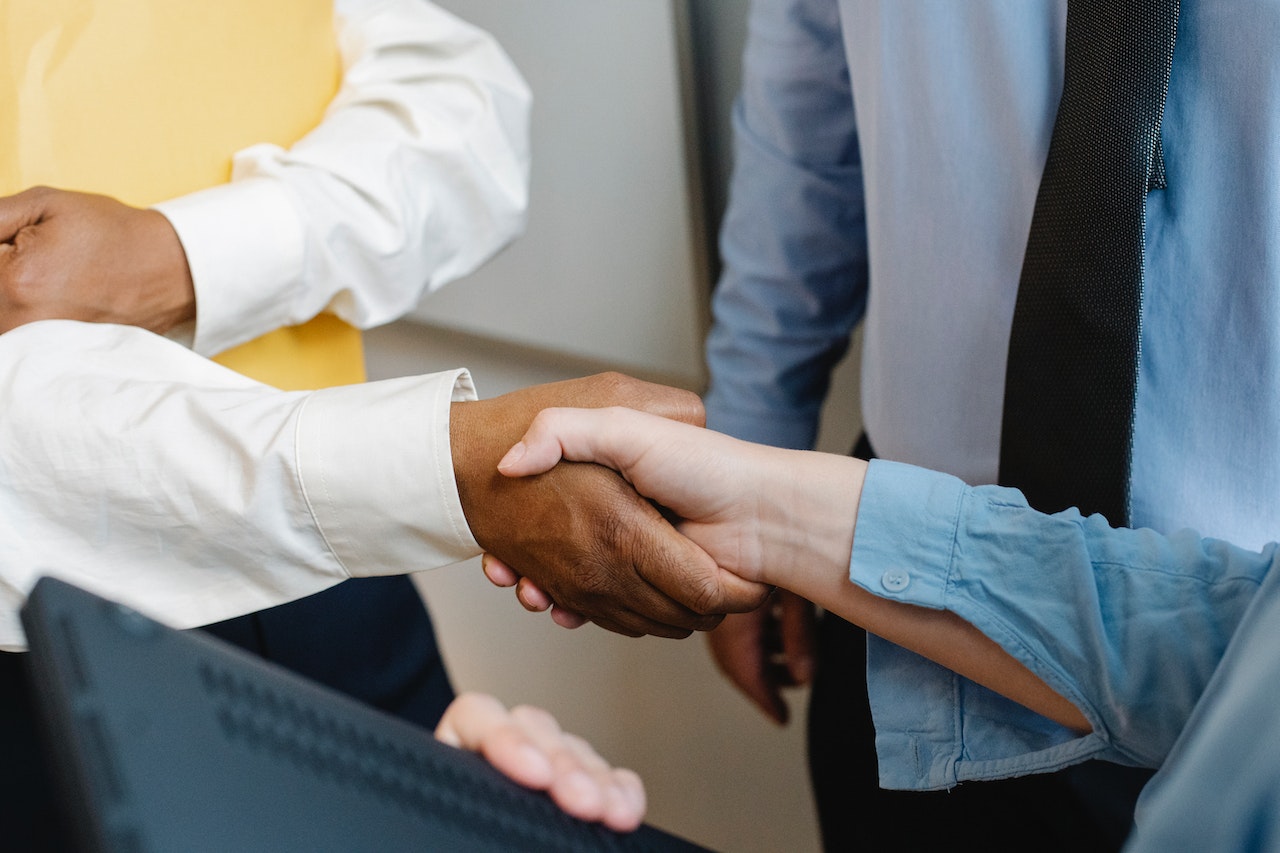 Seller shaking hands after successfully using tips to negotiate with a supplier